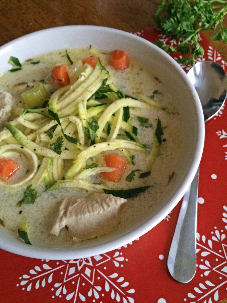 Easy chicken zoodle soup in white bowl with spiralized zucchini noodles