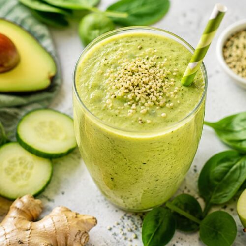 MS-friendly green smoothie with avocado, spinach, cucumber, and hemp seeds in a glass with a green straw