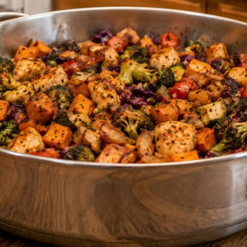 Sweet potato breakfast hash with sweet potatoes, broccoli, peppers, cabbage, and onions cooked in a stainless steel skillet.