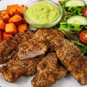 Healthy Idaho finger steaks served with roasted sweet potatoes and fresh green salad on a white plate